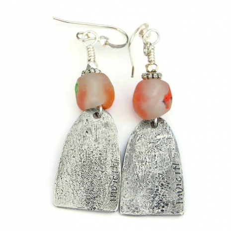 back side of handmade folk art women earrings showing the maker's mark