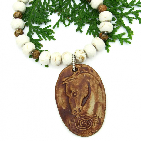 The one of a kind, handmade "Spirit Horse" necklace features an artisan created horse head and spiral ceramic pendant, faceted magnesite, picture jasper and sterling silver - beautiful jewelry for the woman who loves horses. Unique spirit horse pendant necklace with magnesite and picture jasper.