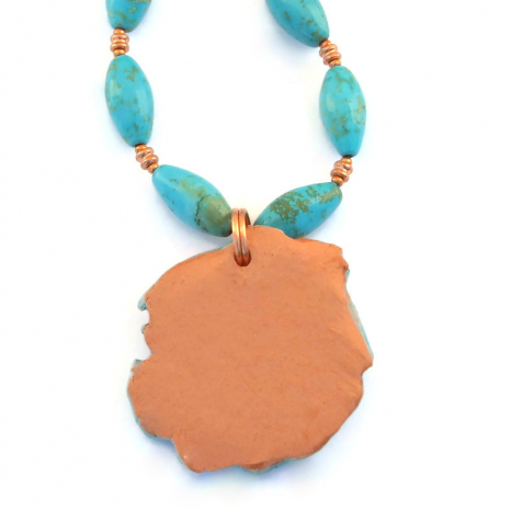 unglazed back side of terracotta face pendant